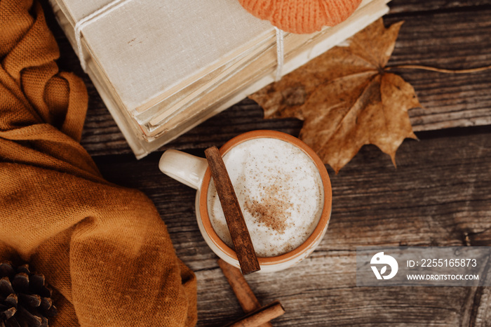 Hot spicy coffee and pile of old books on wooden background