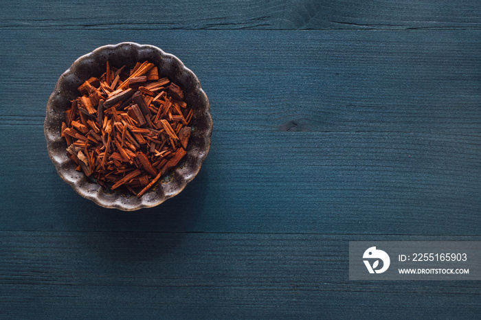 Ceramic Bowl of Red Sandalwood on Blue Stained Wood