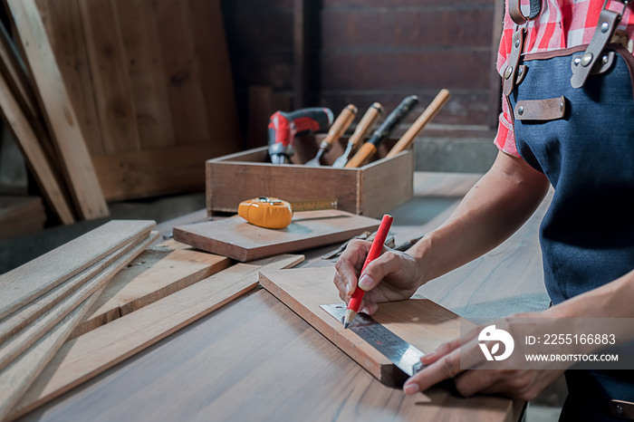 Carpenter working with equipment on wooden table in carpentry shop. woman works in a carpentry shop.