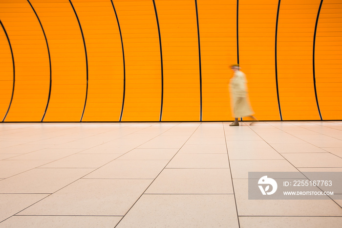 People rushing through a subway corridor (motion blur technique is used to convey movement)