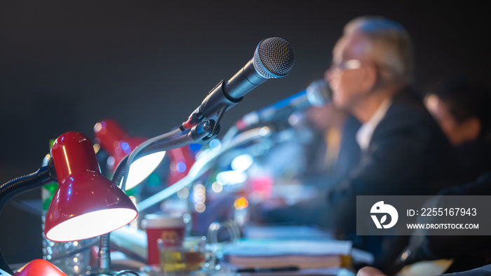 Business people talking on seminar panel with microphone