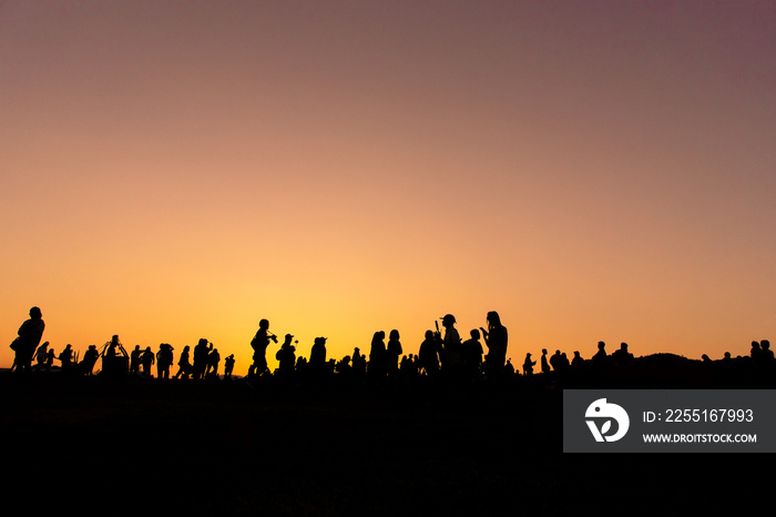 silhouette People and tourists Doing activities and taking pictures of the sunset in the evening.