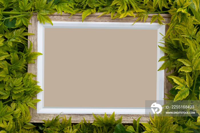 A real wooden frame covered with plants and leaves