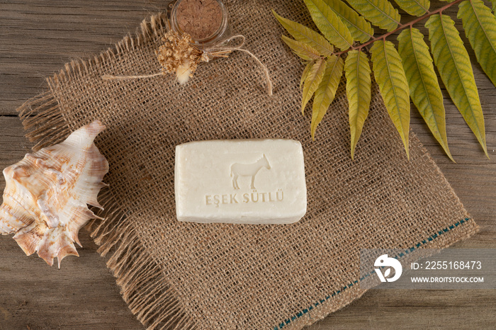 natural collagen soaps made with donkey milk stil life photo. leaves and soap on wooden background