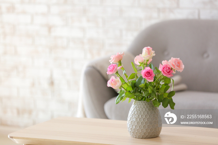 Beautiful rose flowers in vase on table in room