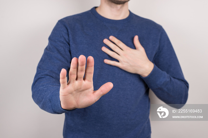 Cropped closeup studio photo portrait of unhappy sad upset guy making holding hand in front of camera on chest isolated grey background