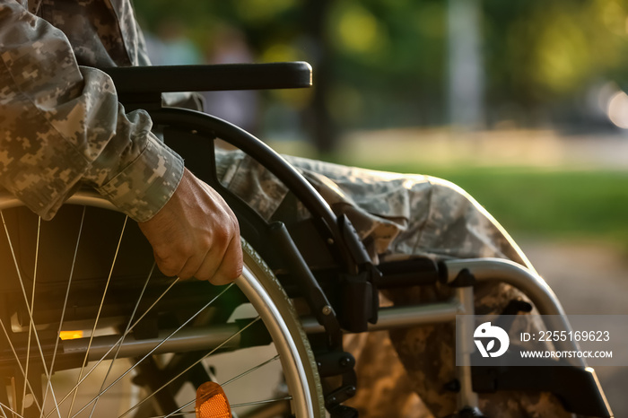 Young soldier in wheelchair outdoors, closeup