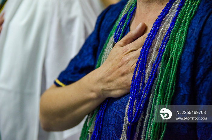 Mão no coração de pessoa orando em culto na Umbanda