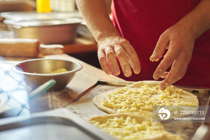 Close-up hands of male baker preparing traditional Georgian cuisine khachapuri