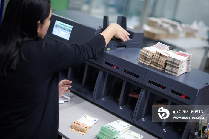 Bank employees sorting and counting paper banknotes