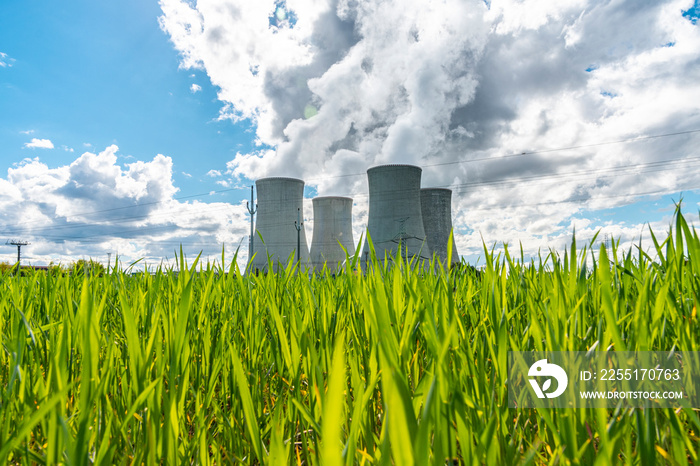 Cooling tower of nuclear power plant behind green grass. Atomic energy. Nuclear power and the environment.