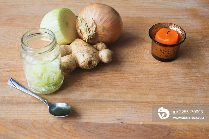 Homemade onion syrup with ginger on wooden background