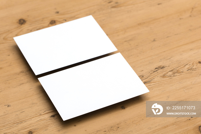 Blank white business card postcard flyer on a wooden background