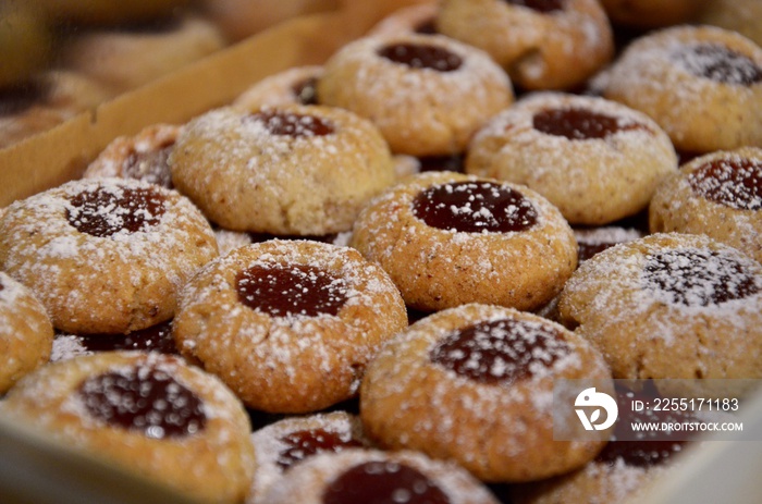 Traditional homemade German Christmas cookies Husarenkrapferl (Hussar donuts) or Engelsaugen (Eyes of an Angel), red currant jam filling, powdered sugar on top