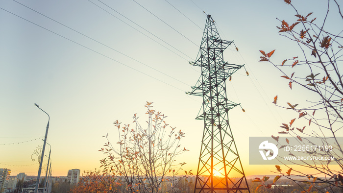 A power line is a system of energy equipment, designed to transmit electricity by means of an electric current. High voltage electric transmission tower at sunset. Copy space.