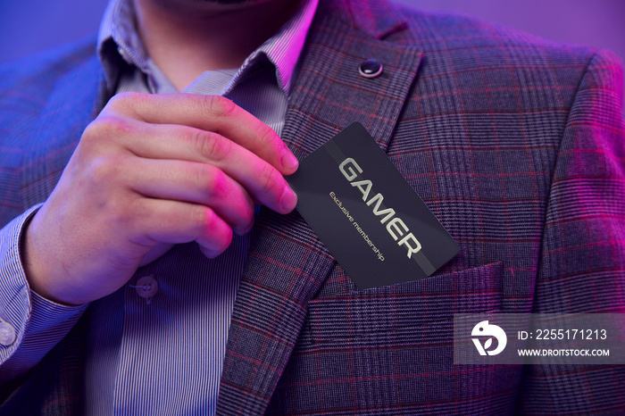Man’s hand puts gamer clubcard into the pocket. Gentleman in suit holds gamer exclusive membership club card in his hand and puts it into the front pocket of his suit.