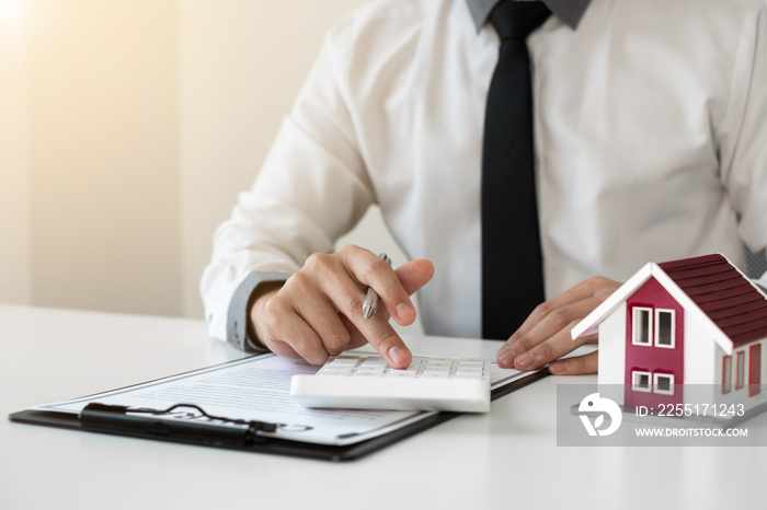 Businessman working real estate and investment, checking a contract document of home loan insurance in the office.