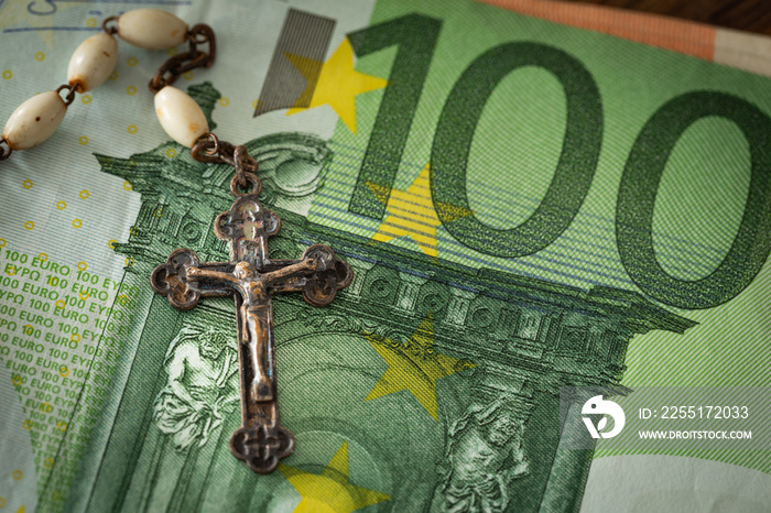 Catholic cross on a background of money / concept