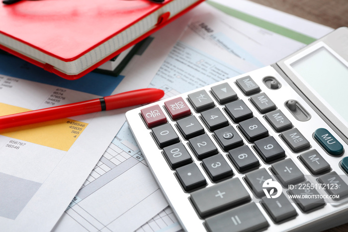 Calculator with documents and pen on table. Tax concept