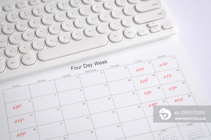 Calendar with four day work week, off days on Friday, Saturday and Sunday. Office desk with keyboard.