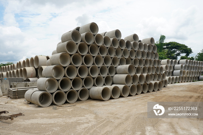 Stacked cement drainage pipes at concrete factory. Reinforced concrete pipes. Industry manufacturing concept.