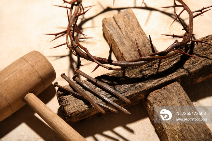 Crown of thorns with wooden cross, mallet and nails on grey background