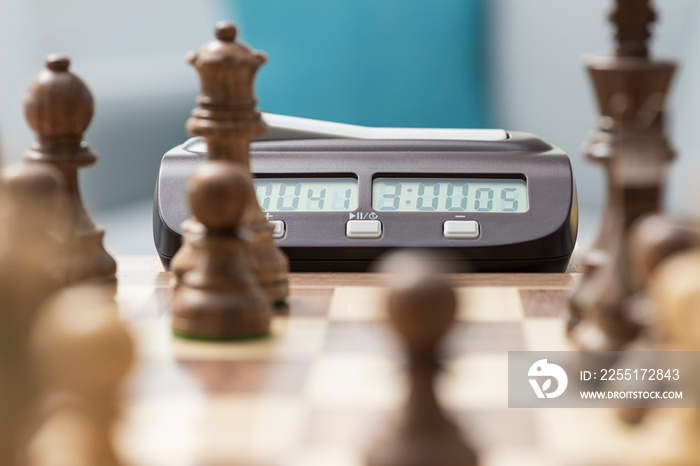 Chessboard with pieces arranged and chess clock