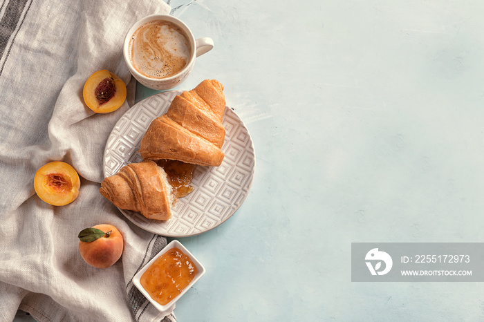 Plate and wooden board with tasty croissants on light table