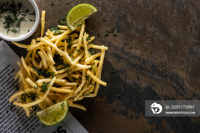 top view of tasty french fries, lime and garlic sauce on marble surface