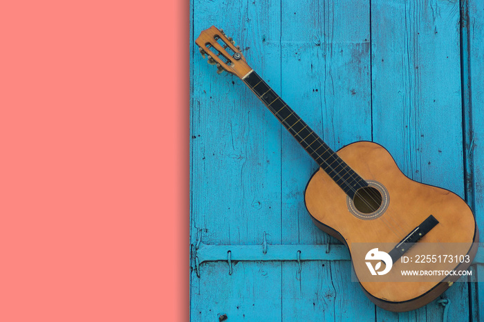 Acoustic guitar hanging on a blue wooden door