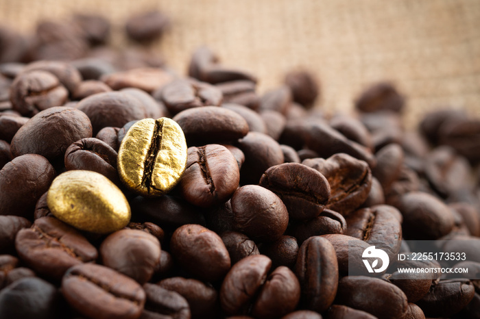 Gold coffee beans on a pile of coffee beans. The concept of luxury is extraordinary.