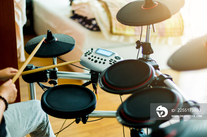 Asian girl put black tshirt and headphone learning and play electronic drum wooden drumsticks