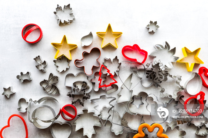 Top down view of many assorted cookie cutters against a light background.