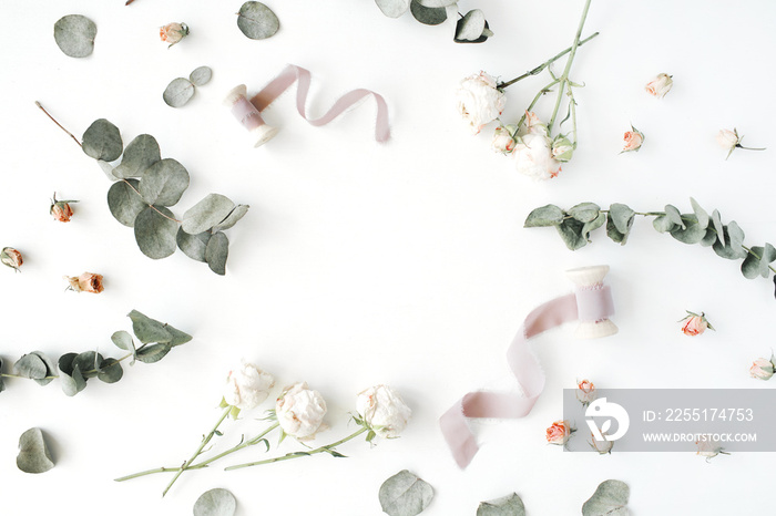 empty wreath frame with roses, eucalyptus branches, leaves and spool with ribbon isolated on white background. flat lay, overhead view