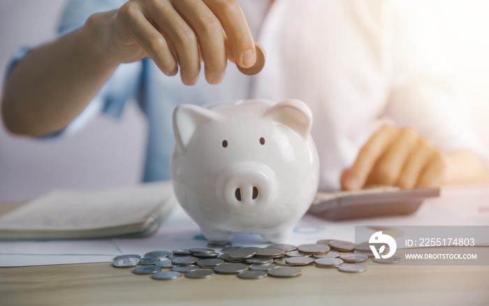 man puts coins in pig piggy bank