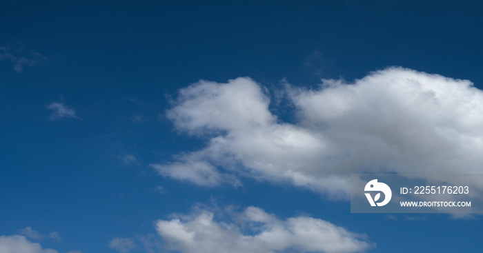 Sky overlay for digital art. Scenic white fluffy clouds moving softly across a clear blue sky