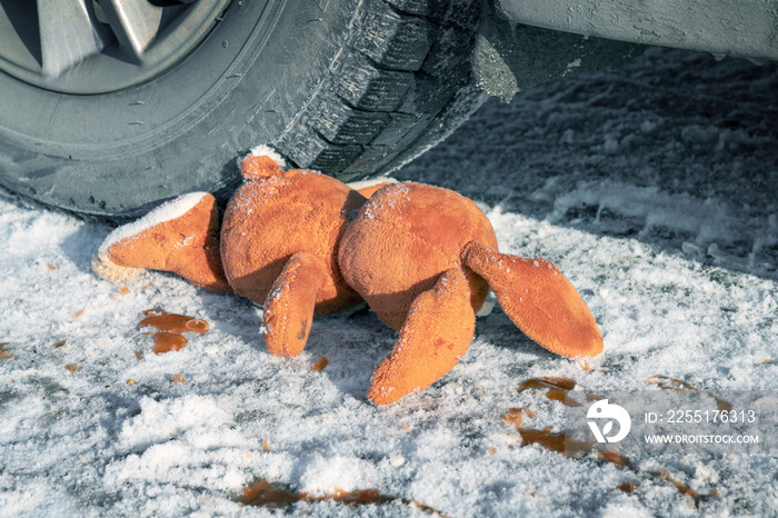 children’s accident on a winter road, Bunny rabbit toy. Death on the road, carelessness and danger. Attention and caution. roadkill winter, blood on snow. Concept