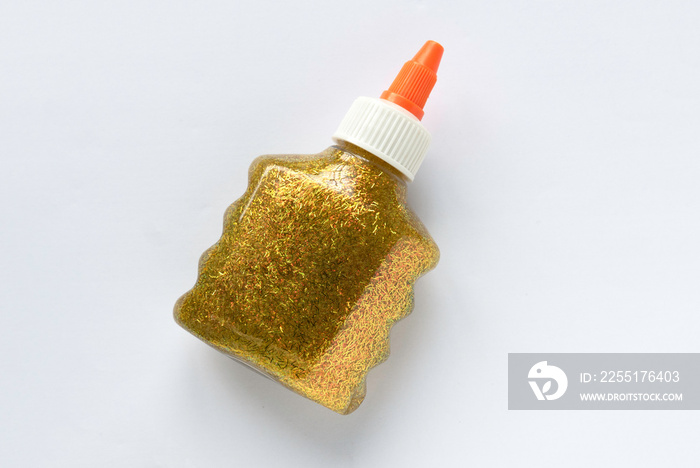 A bottle of gold glitter shining glue on white background.