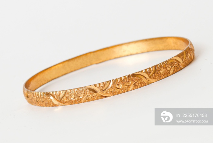 Gold bangle isolated on white background. Celebrity lifestyle accessories. Crazy rich lifestyle. Model Accessories