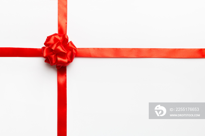 Top view of Red ribbon rolled and red bow isolated on colored background. Flat lay with copy space