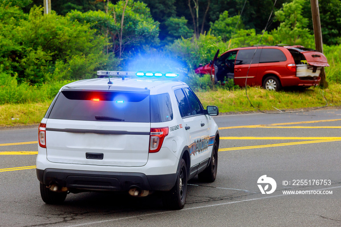 Police flashing blue lights at accident damaged car