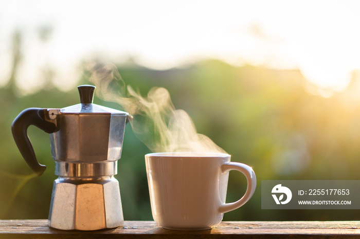 Beautiful sunrise lighting in the morning with a hot coffee and Moka Pot close up with copyspace.