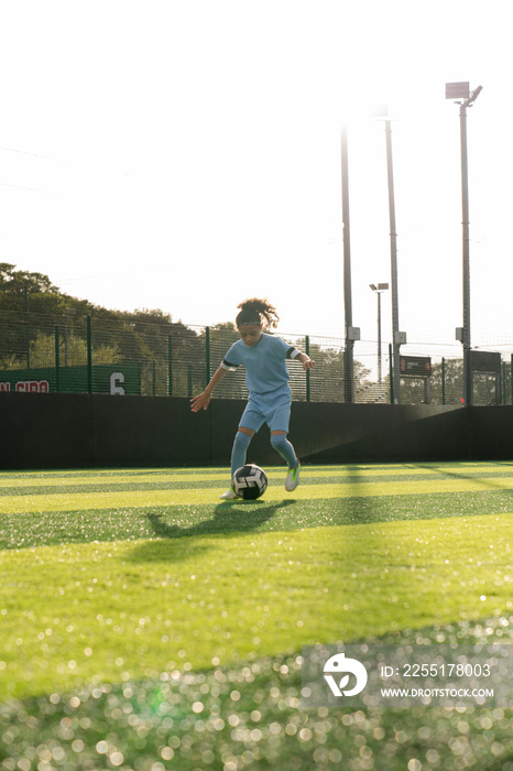 Girl (6-7) playing soccer on soccer field