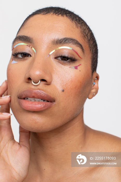 Studio portrait of woman with golden foil make-up