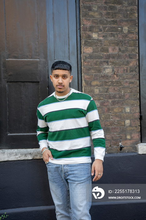 Young man wearing striped sweatshirt and jeans