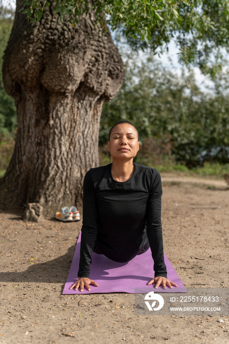 Woman in upward facing dog position in park