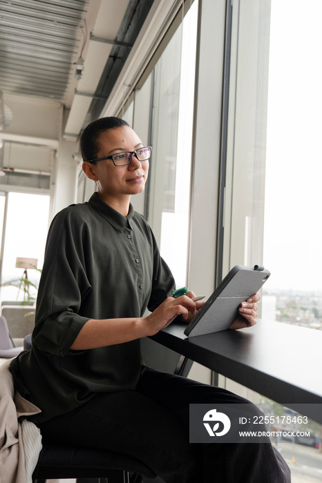 Woman using digital tablet in office