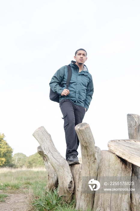 Portrait of man with backpack standing on old wooden posts