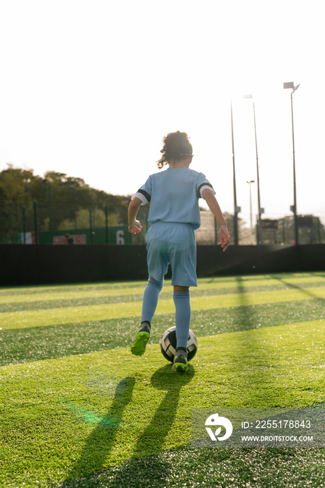 Girl (6-7) playing soccer on soccer field