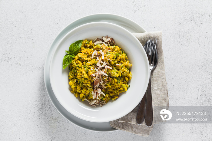 risotto with zucchini and turmeric or saffron in a plate on the table. healthy italian food